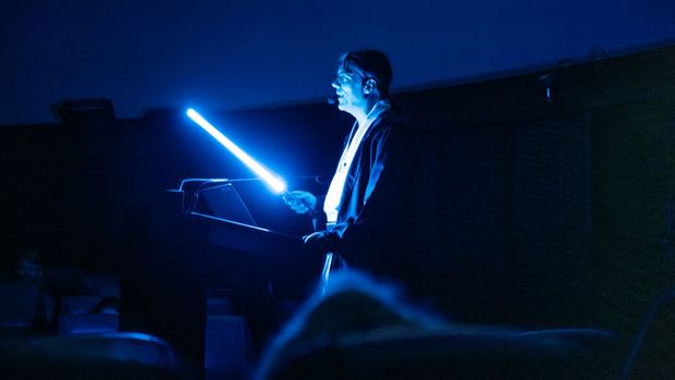 Ein Foto von Tobias Jogler im Jedi Kostüm mit einem Lichtschwert in der Hand.