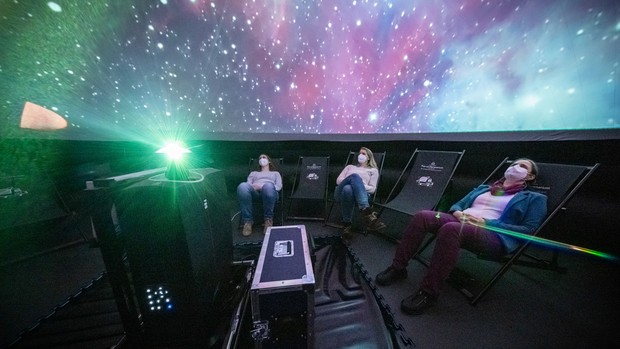 Personen bei einer Vorführung im mobilen Planetarium. Foto: LWL, Steinweg