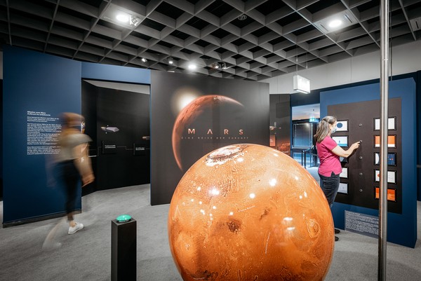 Museumbezoekers maken bij de tentoonstellingssectie "Overlevingskunstenaar mens" kennis met de droom van een missie naar Mars. Foto: LWL/Steinweg