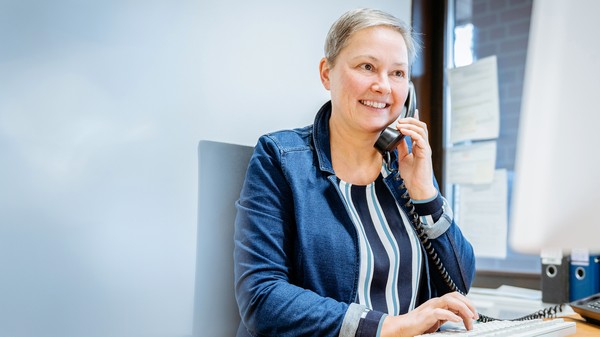 Mitarbeiterin bei einem Beratungsgespräch am Telefon.