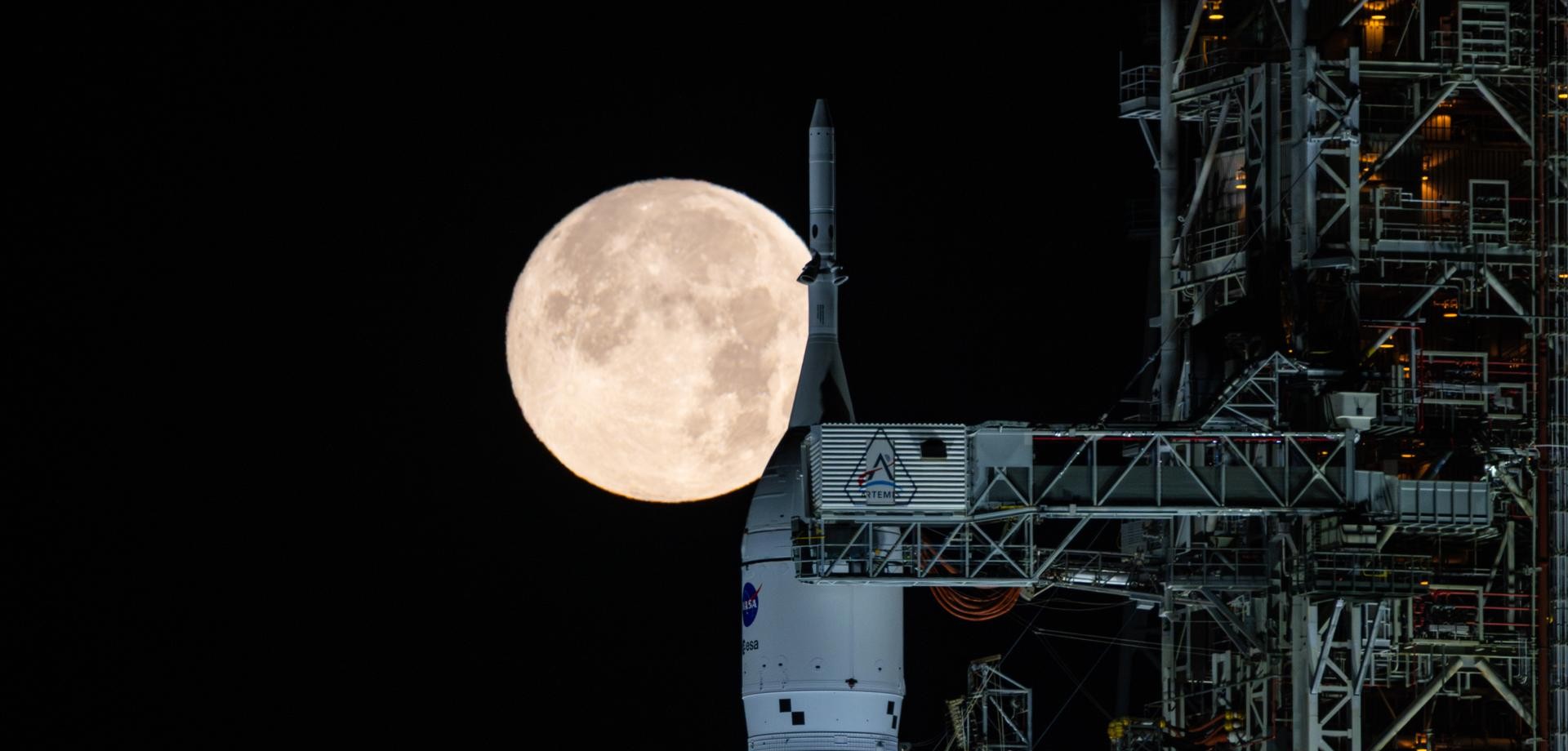 Ein Foto der Artemis II Rakete vor dem Vollmond.