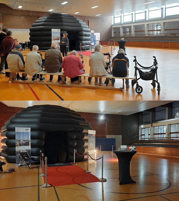 Eine Gruppe Senioren sitzt auf einer Bank vor dem Pop-up-Planetarium.