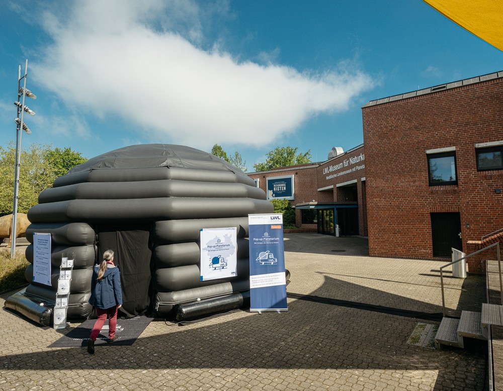 Das Pop-up-Planetarium steht auf dem Vorplatz des LWL-Museums für Naturkunde. Eine Frau geht in das Zelt.