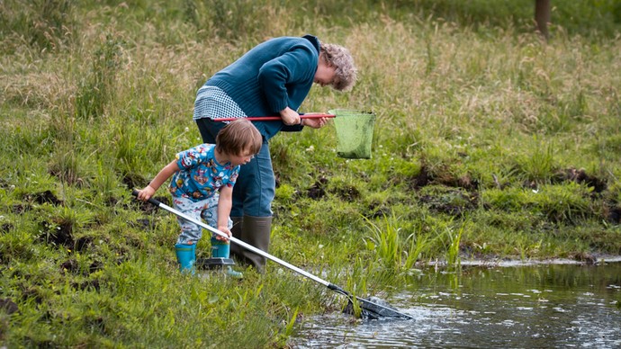 Mann und Kind käschern in einem Gewässer. Foto: LWL/Kriegs