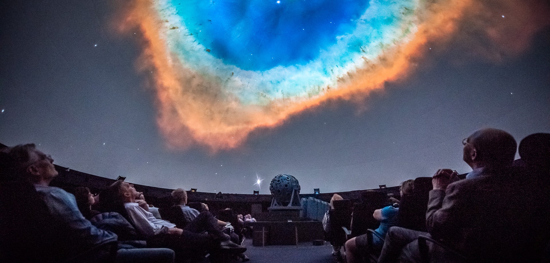 Planetariumsbesucher blicken an die Kuppel und betrachten die Show. Foto: LWL/Steinweg
