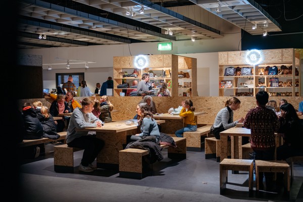 People sitting, chatting and eating in the break area of the museum.