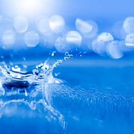 Wassertropfen trifft auf Wasseroberfläche.