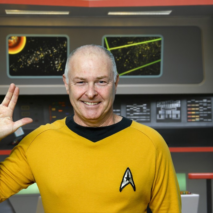 Ein Mann in Starfleet-Uniform hält die Hand zum vulkanischen Gruß erhoben. (vergrößerte Bildansicht wird geöffnet)