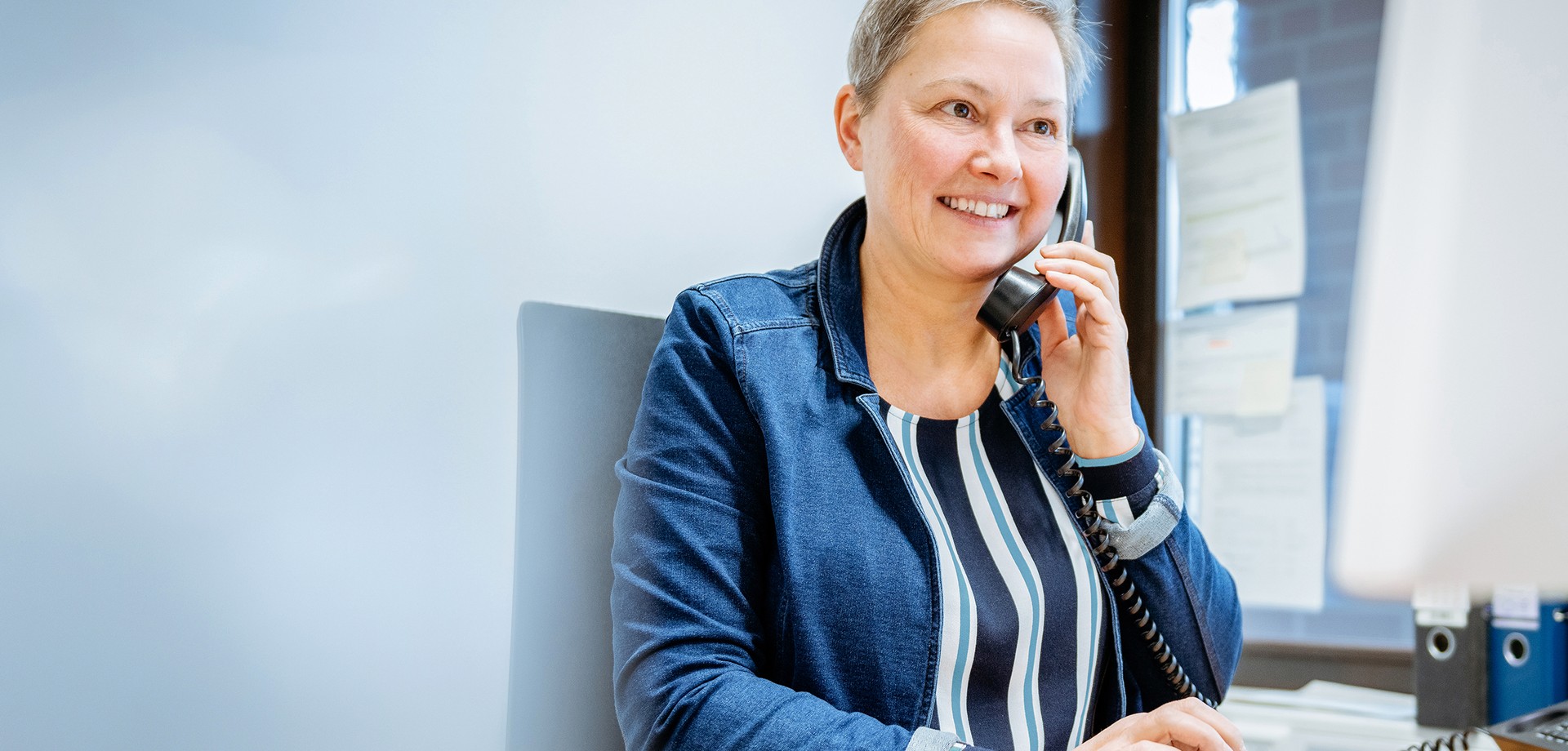 Mitarbeiterin bei einem Beratungsgespräch am Telefon.