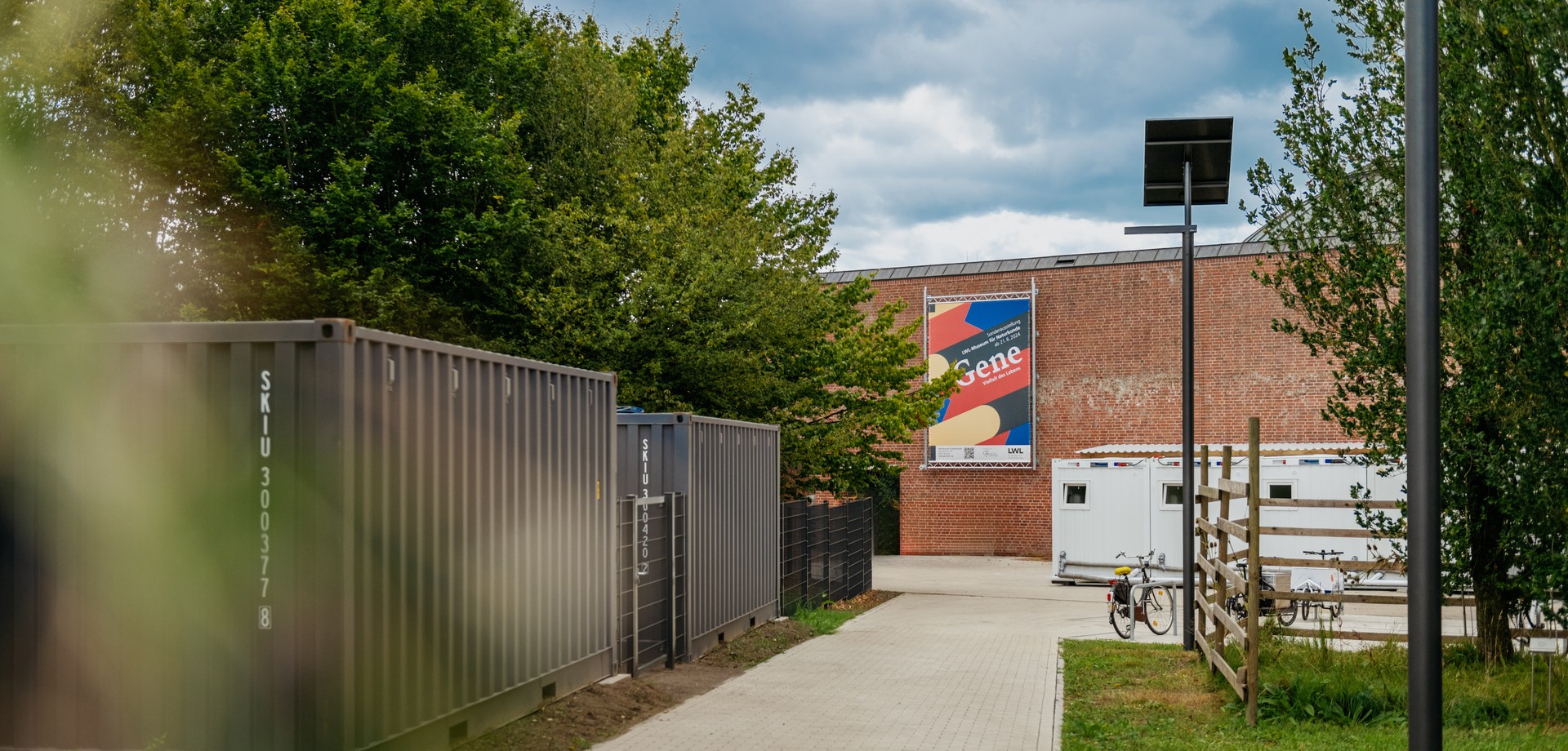 Museum with surrounding green spaces and the objects on the forecourt.
