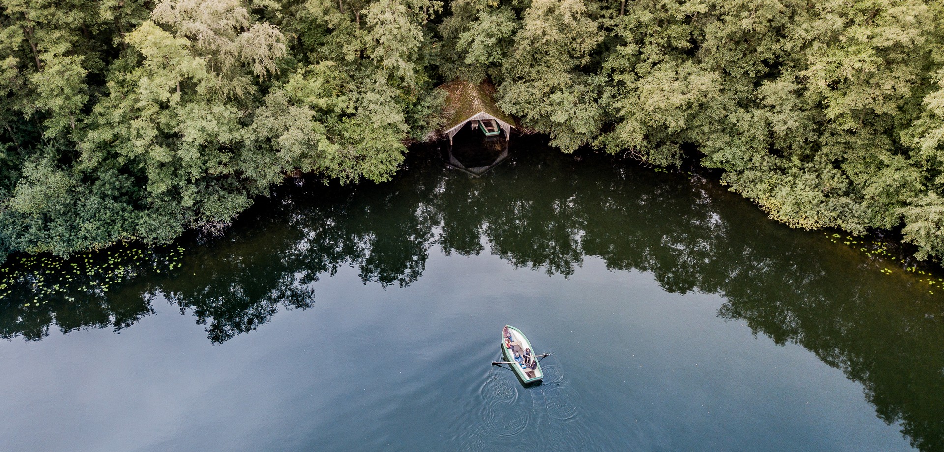 Personen erkunden das Naturschutzgebiet Heliges Meer mit einem Boot. Foto: LWL/Steinweg