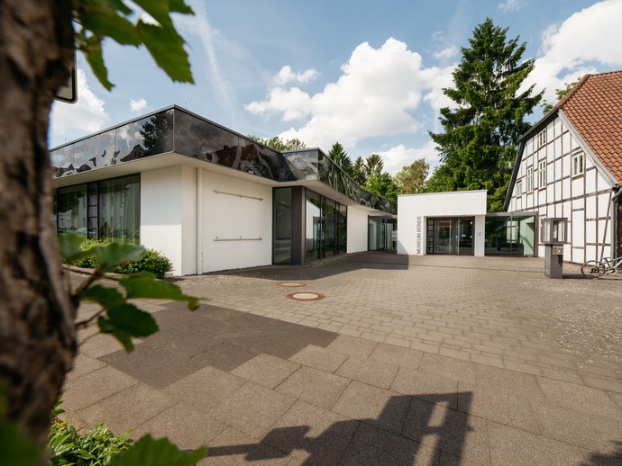 Außenansicht des Dobergmuseums mit Baum im Vordergrund und Eingangsbereich. (vergrößerte Bildansicht wird geöffnet)